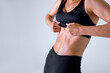 © alfa27 - Cut view of slim well built young woman posing on camera, showing sportive stomach press. Sportswoman showsamazing gorgeous abs muscles. Model in top and shorts. Isolated over gray background