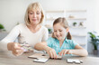 © Prostock-studio - Portrait of happy mature woman and granddaughter solving puzzle
