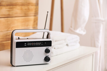 Stylish white radio on table in bathroom, space for text