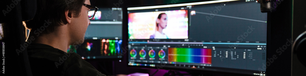 Editor Back Back view of a young white man video editor Stock Photo | Adobe Stock
