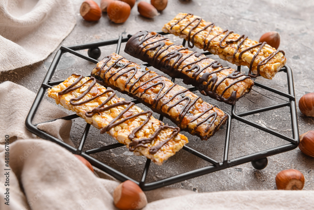 Rack with tasty chocolate nut bars on grunge background