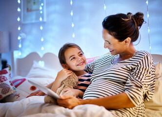 Poster - You picked a good one. Cropped shot of an attractive young pregnant woman reading her daughter a bedtime story on a tablet.