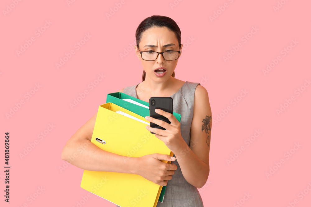 Stressed young woman with folders and phone on color background