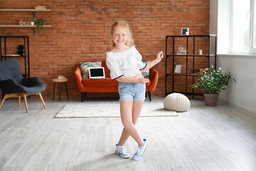 Sticker - Little redhead girl in blouse dancing at home