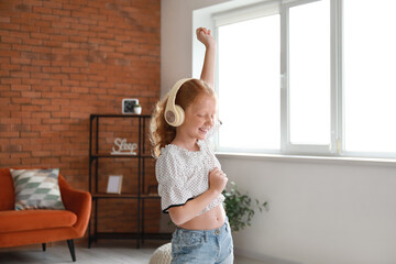 Sticker - Little redhead girl in headphones dancing at home