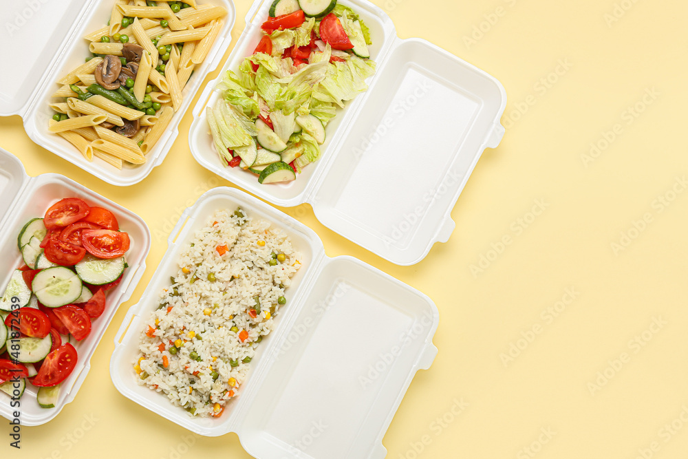 Food delivery containers with delicious meals on color background