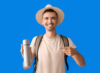 Sticker - Male tourist with thermos on color background