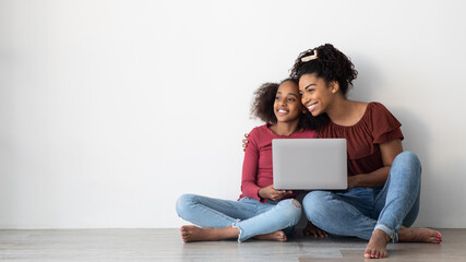 Wall Mural - Happy black mom and teen kid using laptop, copy space