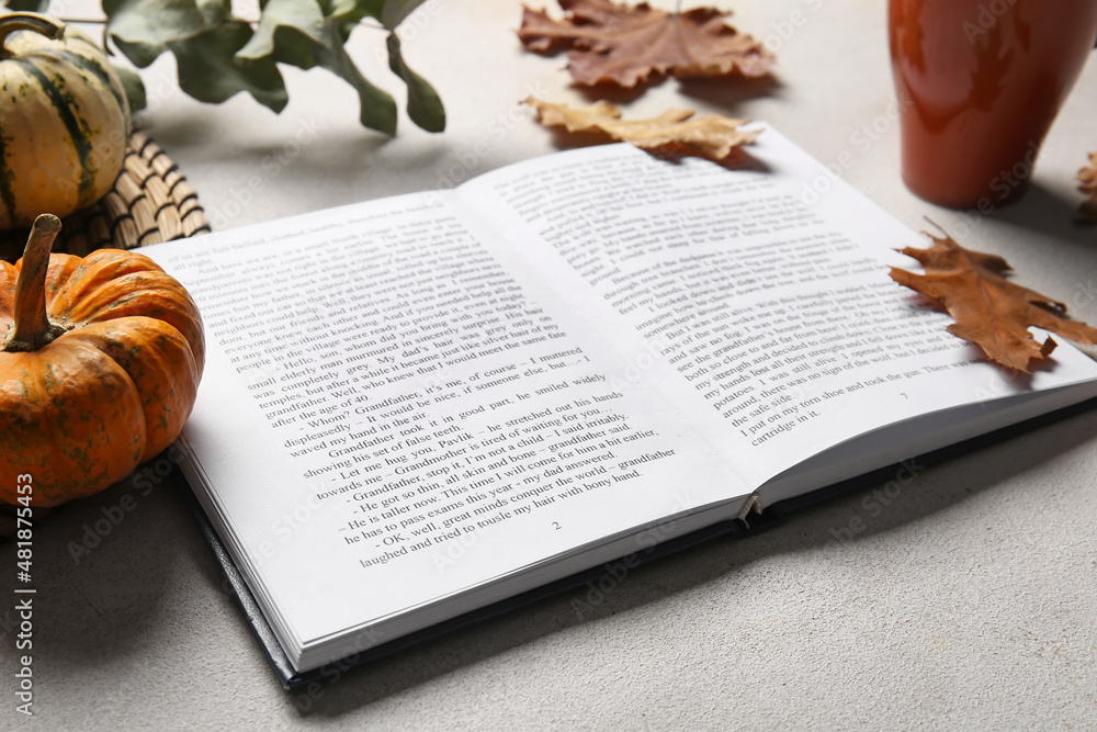 Book and autumn decor on light background, closeup