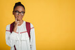Pensive smart teen afro american female pupil in glasses with backpack thinks and looks at empty space