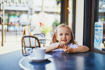 Wall Mural - Adorable three year old girl in Parisian cafe or restaurant