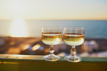 Canvas Print - Two glasses of white wine with Atlantic coast beach in background