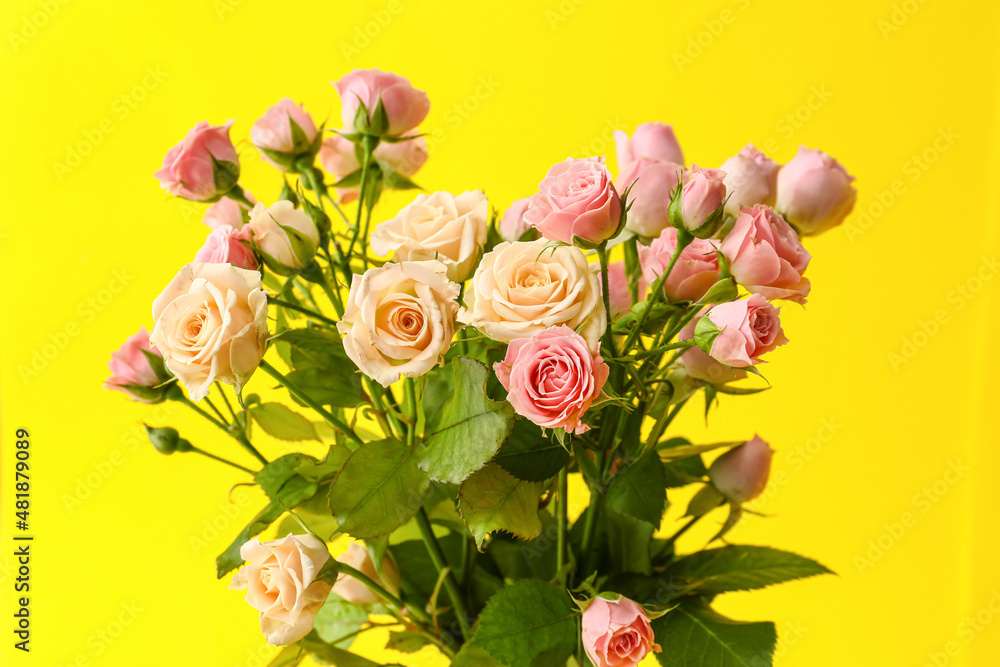 Bouquet of beautiful roses on yellow background