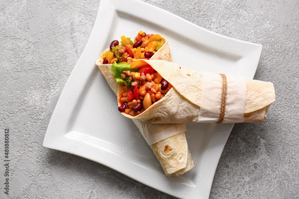 Plate with delicious burritos on grey background