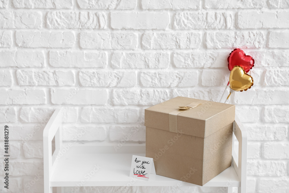 Gift of Valentine's Day on table near white brick wall