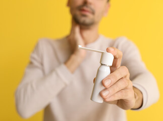 Sticker - Ill young man with inhaler on yellow background, closeup