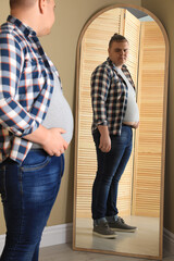 Poster - Overweight man in tight t-shirt near mirror at home