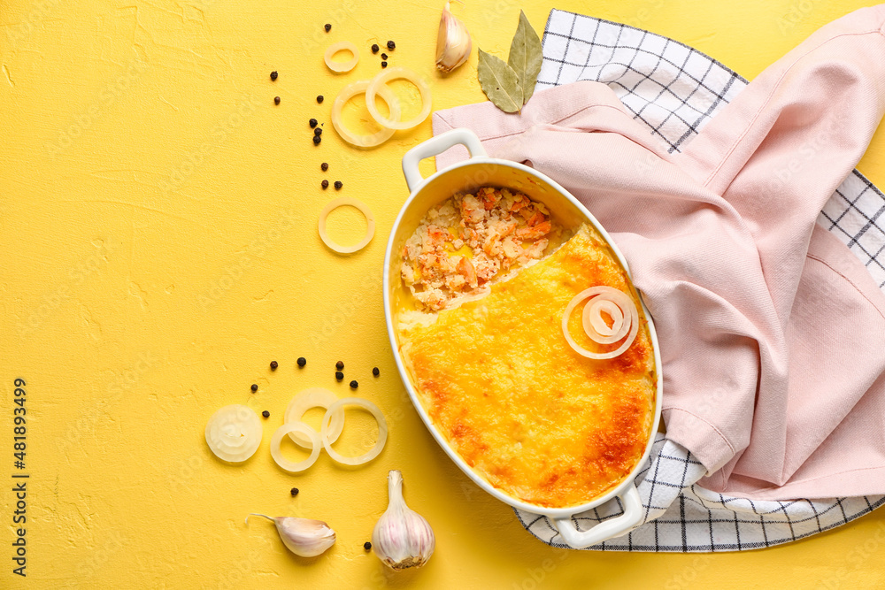 Baking dish with tasty English fish pie on yellow background