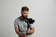 © Volodymyr - Professional bearded videographer holding camera which set on 3-axis gimbal. Videographer using steadicam. Pro equipment helps to make high quality video without shaking.