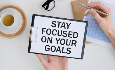 Inspirational quote - Stay focused on your goals. With text message on white paper