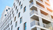 Modern luxury residential flat. Modern apartment building on a sunny day. White apartment building with a blue sky. Facade of a modern apartment building.