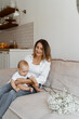 © shamek - mom and baby on the bed with a bouquet of white flowers