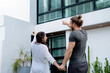 © narong - Couple man and pregnant woman hold their hands and also point to house with concept of new building for family and happiness home.