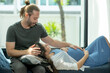 © narong - Caucasian man sit on sofa and his pregnant wife lie down on his leg, he also touch belly of woman with concept of love and care family at home.