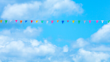 Colorful flag paper with blue sky and cloud background.