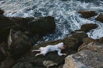 Poster - Barefoot woman in white wedding dress on sea shore wet hair view from above