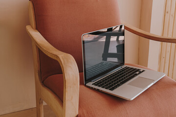 Wall Mural - Laptop on comfortable peach lounge chair