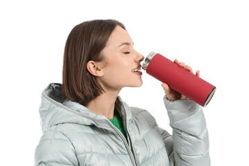 Wall Mural - Beautiful young woman drinking hot tea from thermos on white background