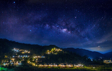Wall Mural - milky way galaxy on a village in a valley in northern thailand. long exposure photograph, with grain