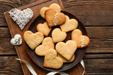 Fototapeta Mapy - Plate with tasty heart shaped cookies on wooden background. Valentines Day celebration