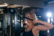 © somemeans - Close-up on beautiful woman in the gym, training triceps on the fitness simulator