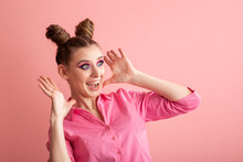 Cheerful Crazy Surprised Girl With Two Bun Hairstyles On A Pink Background. Adults Are Like Children. Pink Mood.