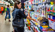 © pavel siamionov - Portrait of young woman choosing school stationery in supermarket.