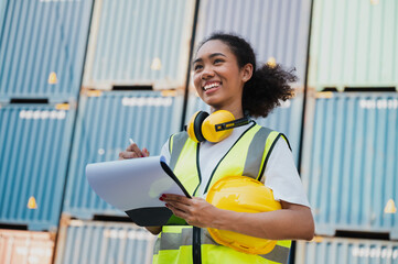 Businesswoman, foreman holding clipboard with container ship background	