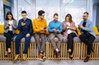 © maxbelchenko - Group of young people using mobile phone. Business colegios sitting side by side in a modern office using digital devices. Study, business, technologies.