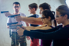 Large Group Of Students With Two Instructors Practice Gun Shooting