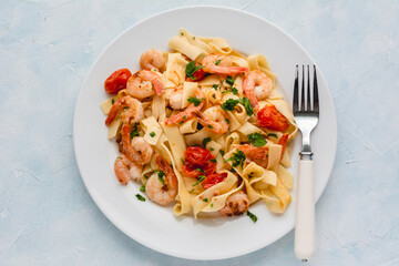 Wall Mural - Pasta with shrimp in a garlic sauce with butter, parsley and cherry tomato.