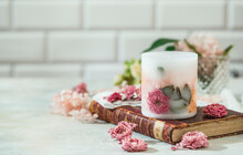 Handmade Candles Of A Unique Design, With Different Flowers, Dry Leaves On A Light Background. Candles Made From Organic Wax, Paraffin Wax. Relaxation Atmosphere. Luxurious Lifestyle.
