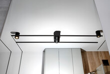 Black Sconce Mounted In A Large Mirror In The Bathroom, Visible LED Lighting In The Shape Of A Tube.