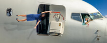 A Stewardess Is Holding The Open Door Of A Flying Plane
