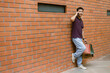 © Pichsakul - shopping concept The guy in a happy face attempting to make a phone call while slanting himself on the wall and bringing plenty of shopping bags with him