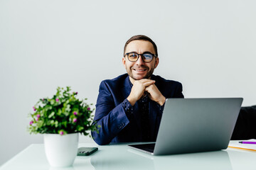 Young dreamy businessman in suit thinking of business vision outlook planning future project idea at work with laptop.