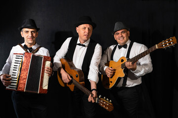 Trio of musicians on a black background	