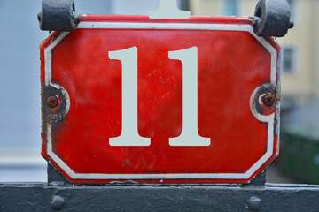 A red number plaque, showing the number eleven (11)