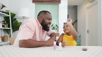 Wall Mural - Happy family African father applying nail polish to little daughter in living room. Dad and child girl kid enjoy and having fun leisure activity spending time together with beauty treatment at home