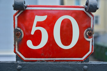 A red number plaque, showing the number fifty, 50
